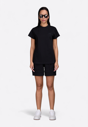 Model wearing East Vibe black T-shirt, front-side view – East Vibe